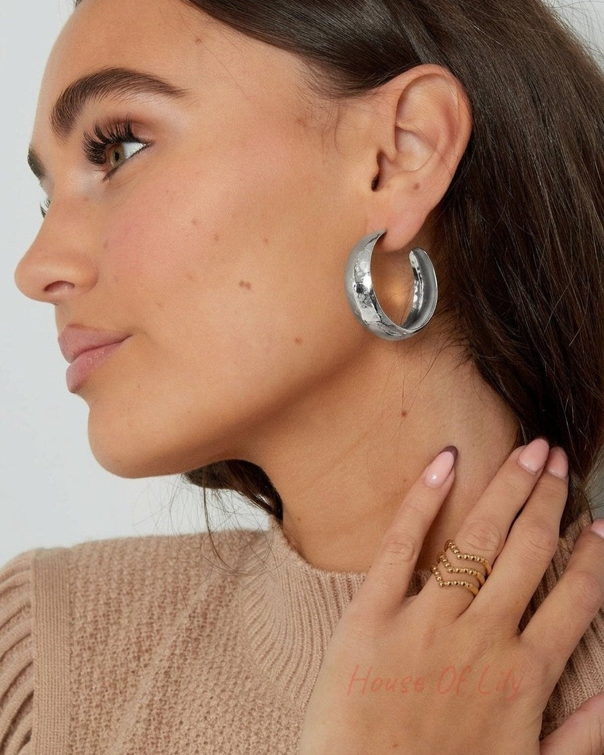 Thick, textured silver hoop earrings with a polished, hammered metal finish.