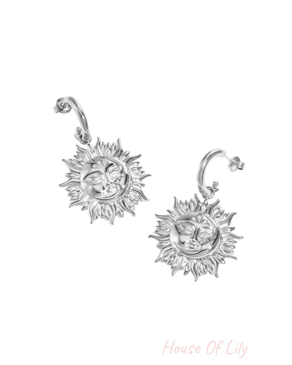 Pair of silver sun face drop earrings with sun motif on white background