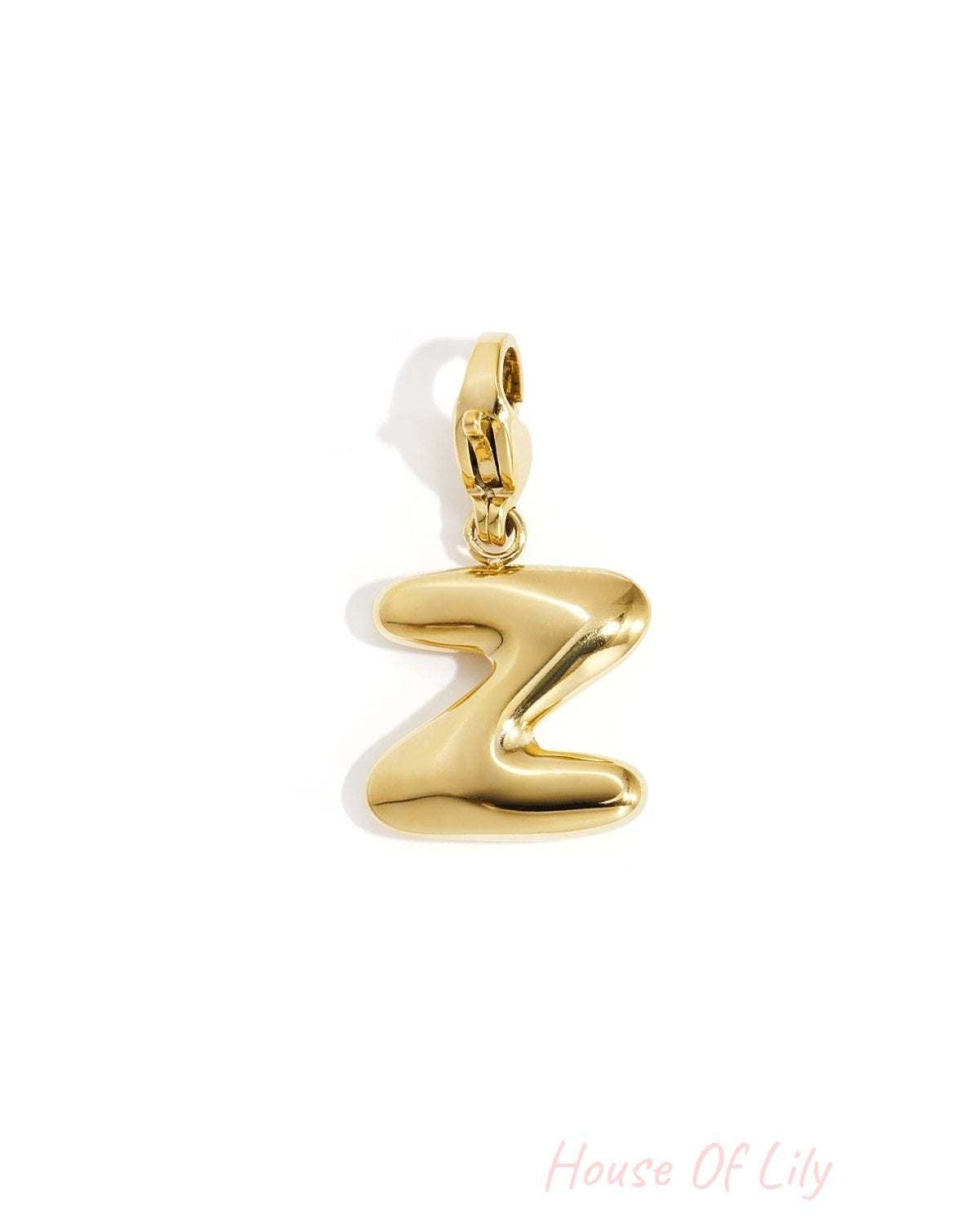 Polished gold-tone initial charm in the shape of the letter Z, featuring a smooth, puffed design and lobster clasp.
