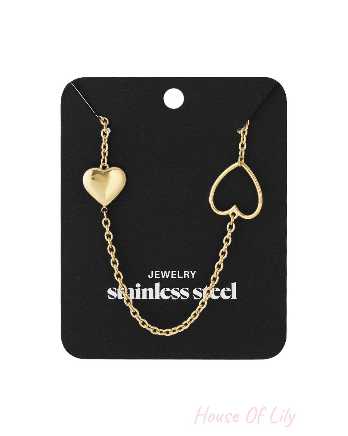 Radiant Heart Link gold-tone stainless steel necklace featuring one solid and one open heart charm on a chain.