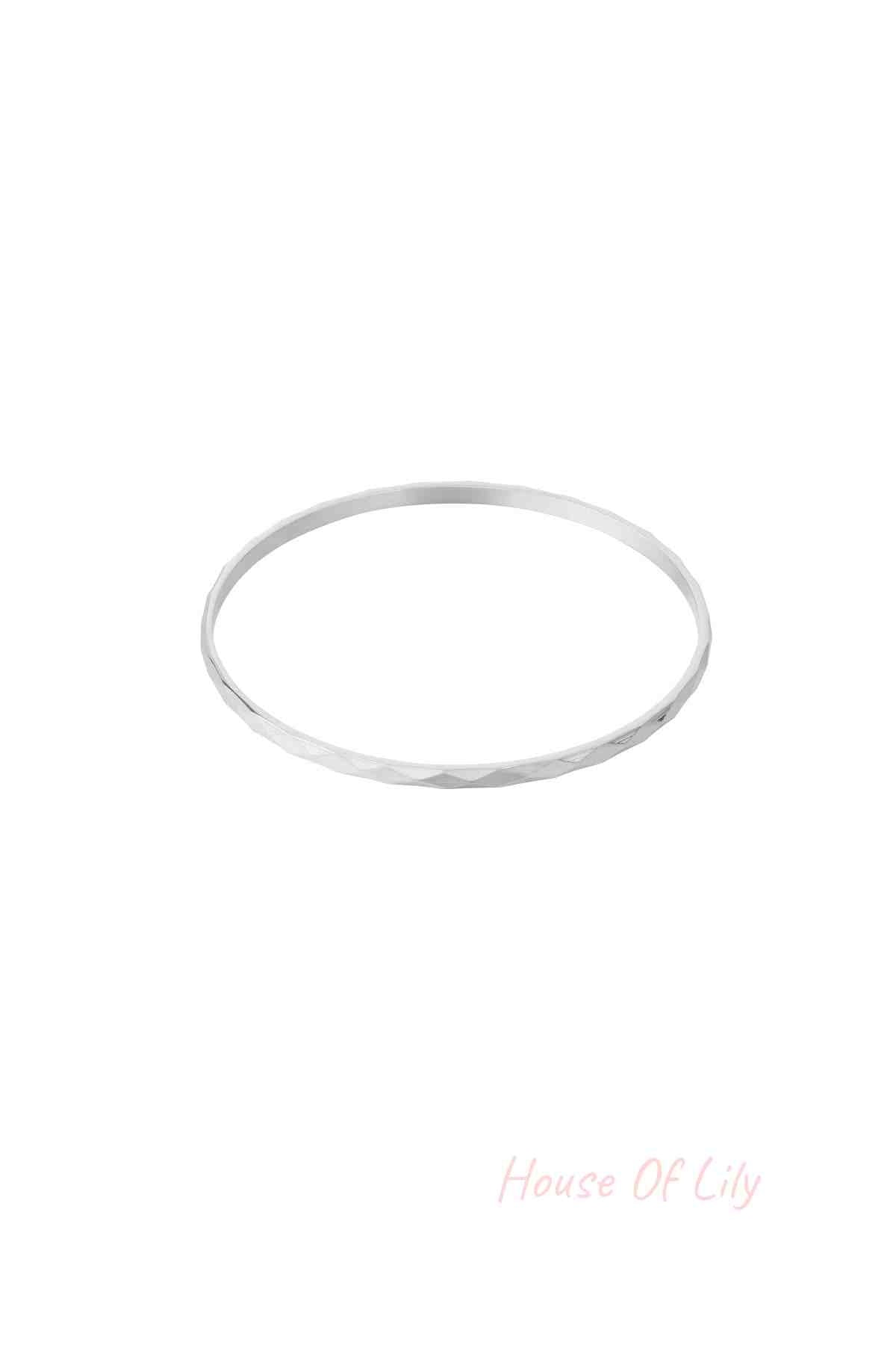 Single silver facet textured bangle bracelet on white background