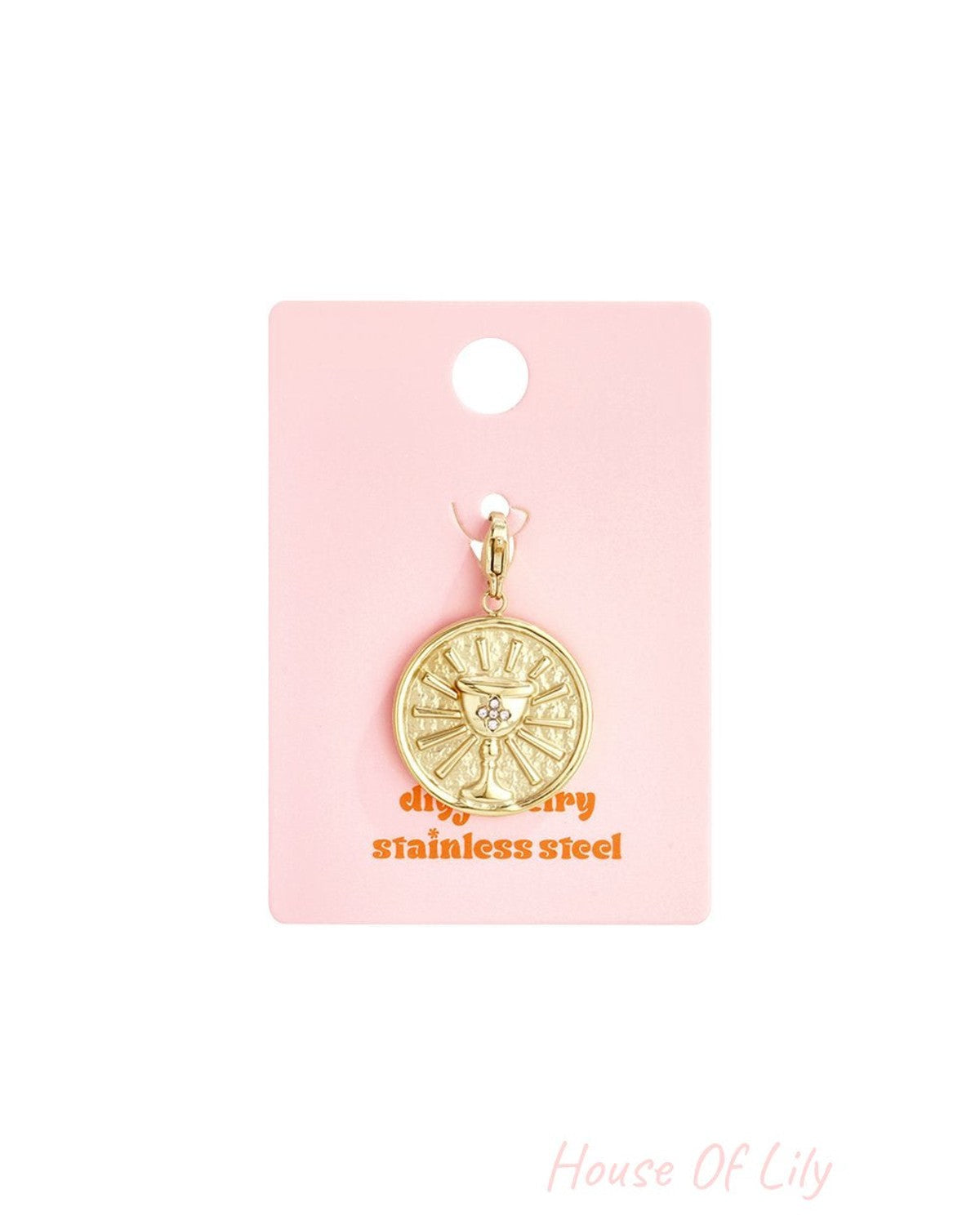 Gold-tone stainless steel coin pendant featuring an embossed chalice and small crystals, on a pink display card.