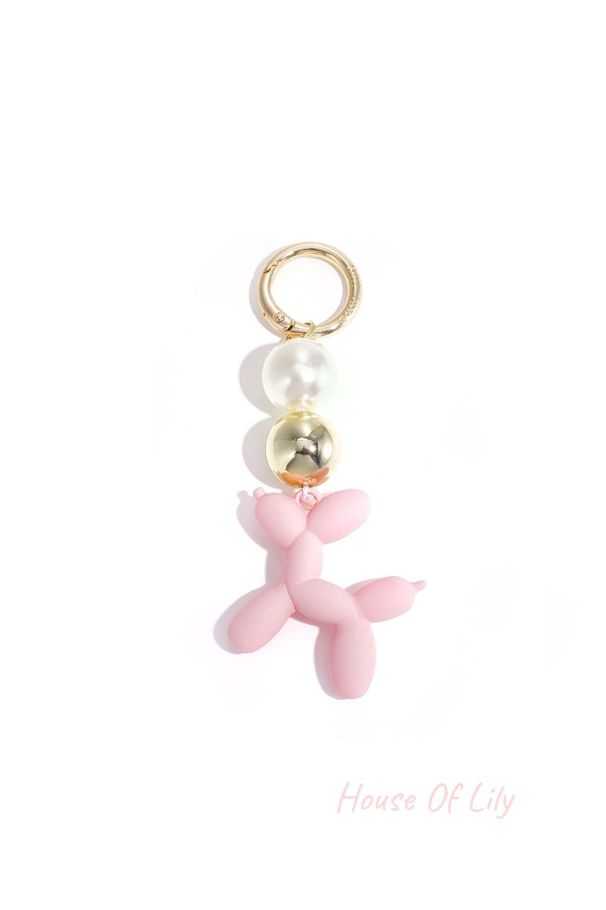 Soft pink balloon dog bag charm with pearl and gold beads on white background