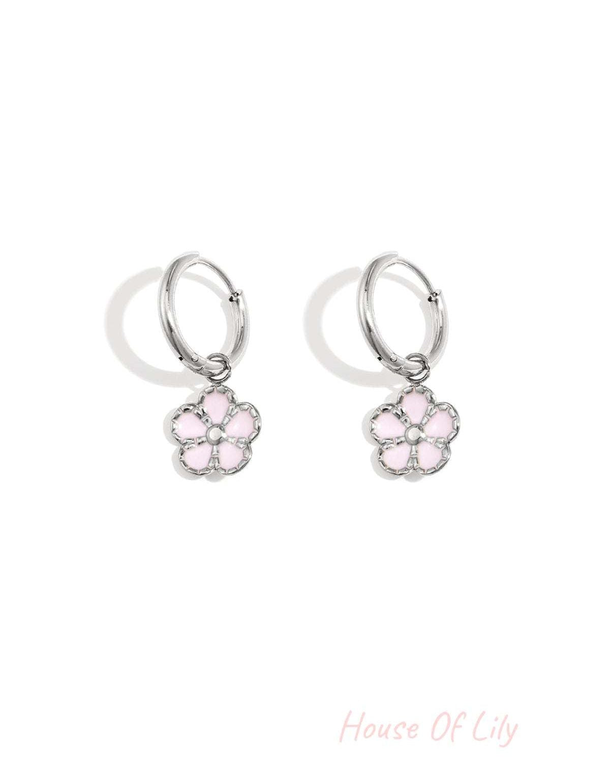 Pair of silver hoop earrings with delicate pink enamel flower charms displayed on a white background