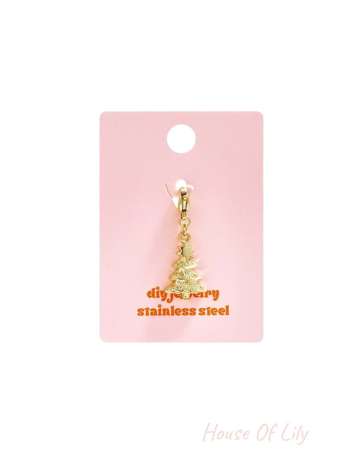 Gold stainless steel Festive Tree charm with a lobster clasp, displayed on a pink backing card.