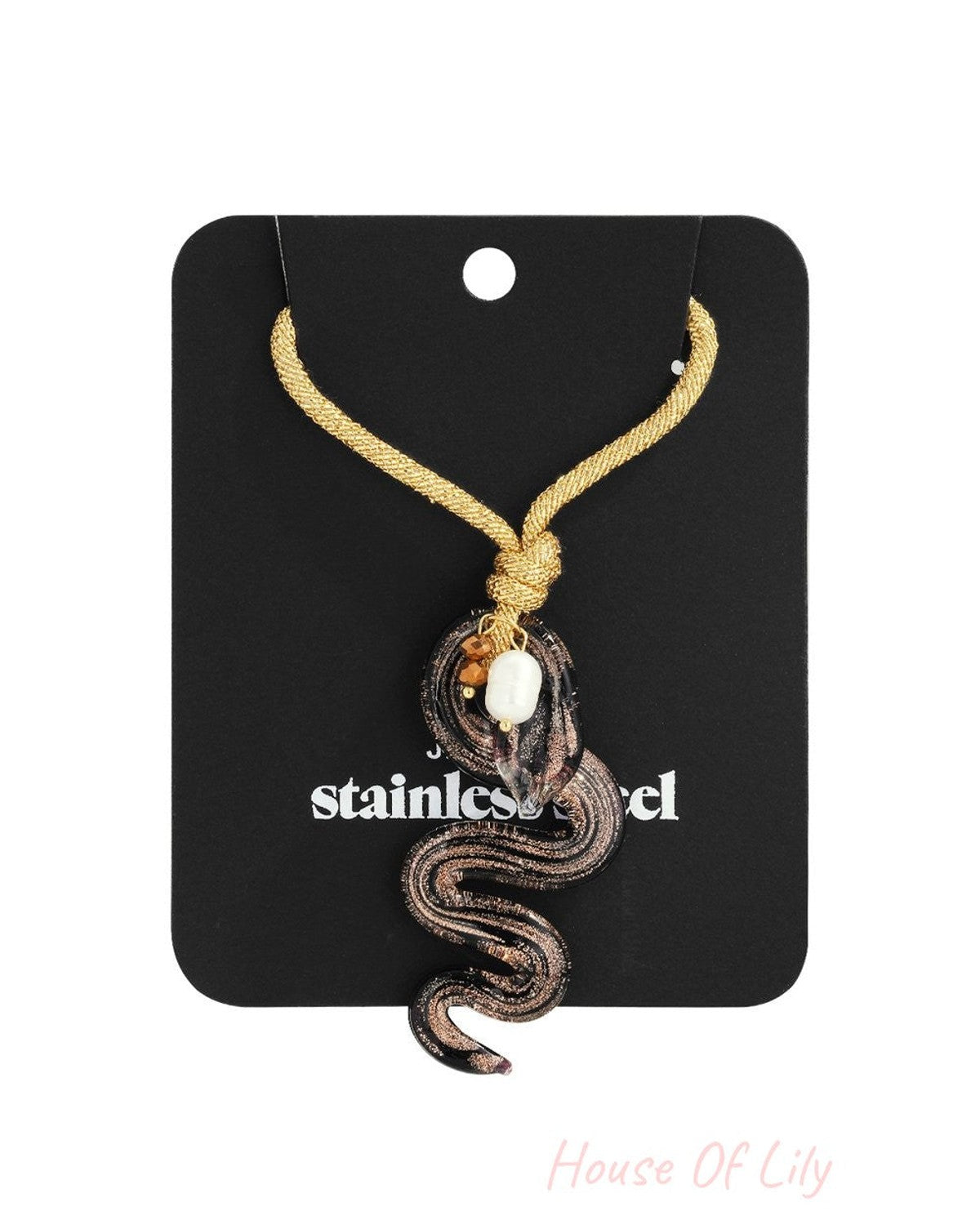 Sss-Tier Snake Vibe necklace features a glass snake pendant in black and copper, accented with a white pearl on gold cord.