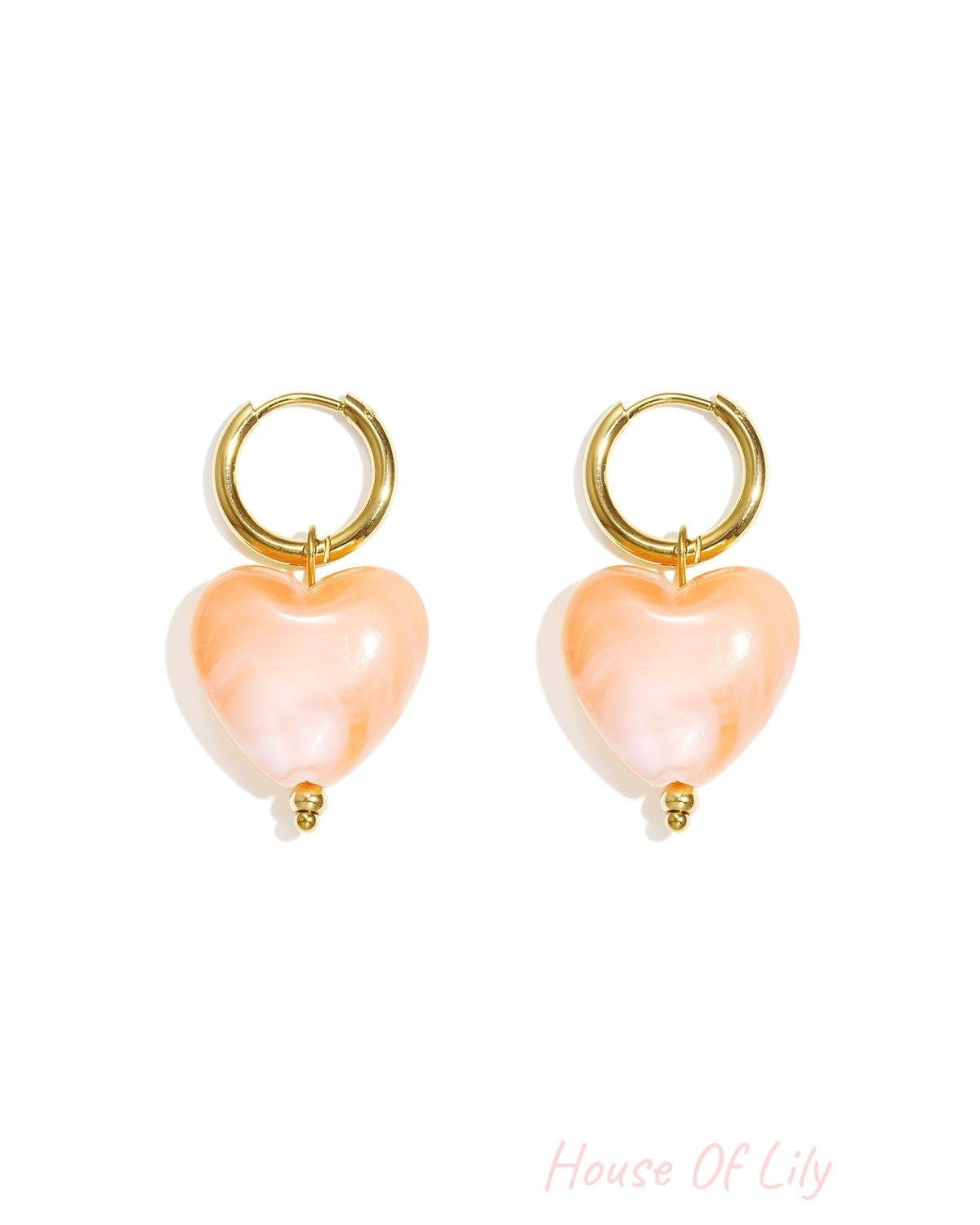 Y2K gold hoop earrings featuring marbled peach-colored heart charms with a small gold bead detail.