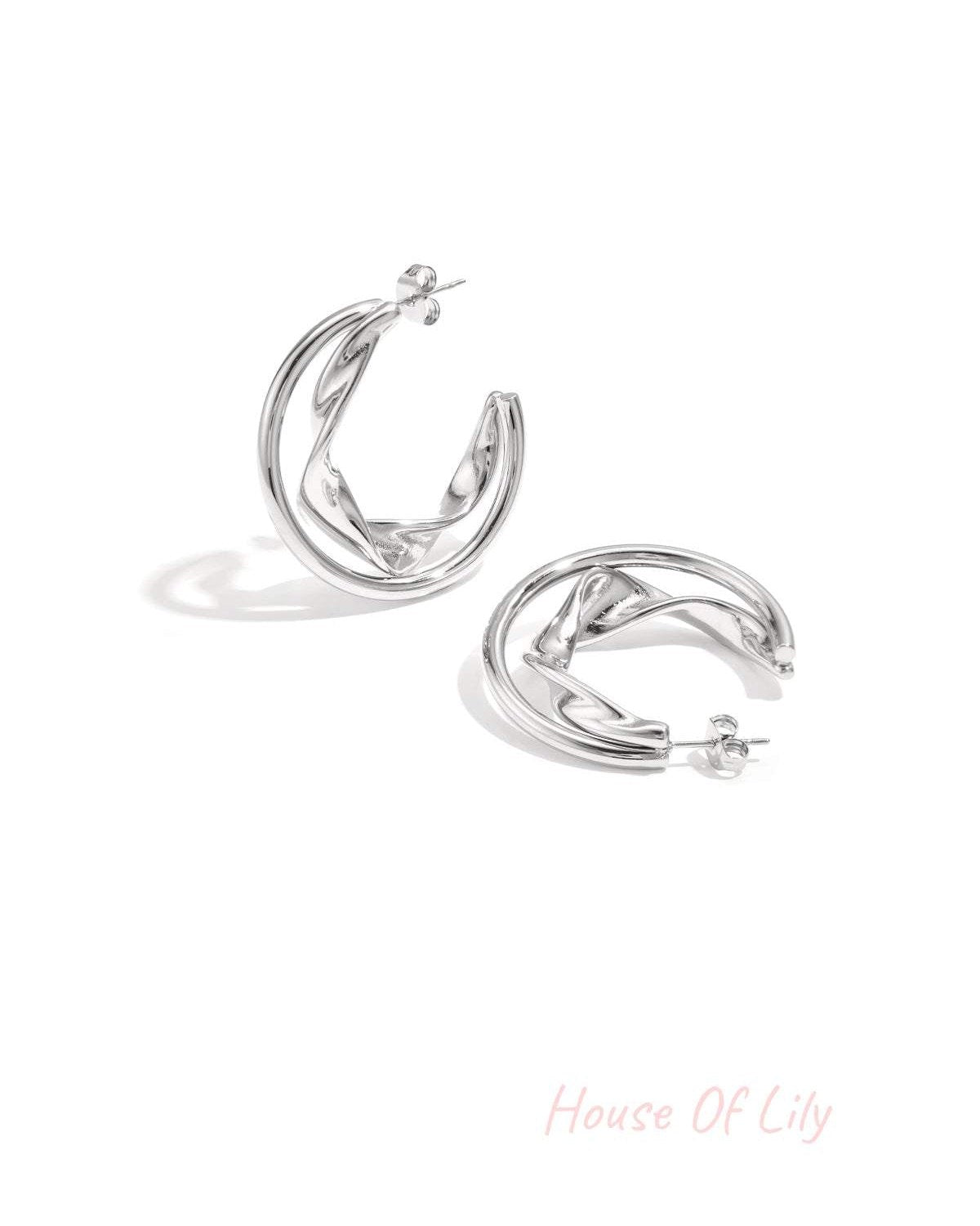 Silver twisted double hoop earrings displayed on white background