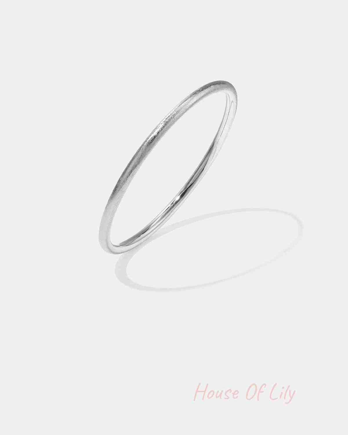 Minimalist silver circle bangle with a soft texture on white background