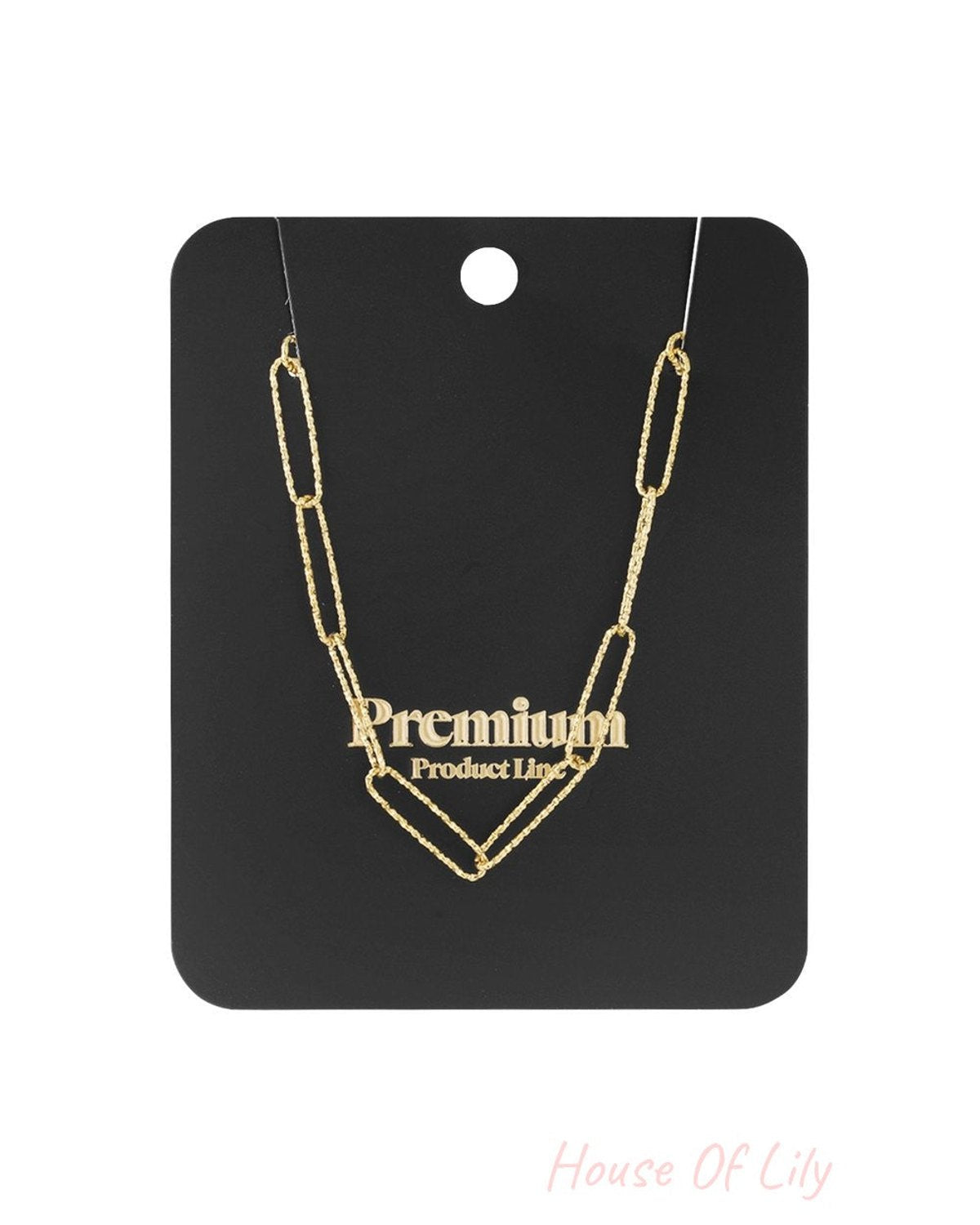 Gold-tone paperclip chain necklace with a textured, elongated link design displayed on a black card.