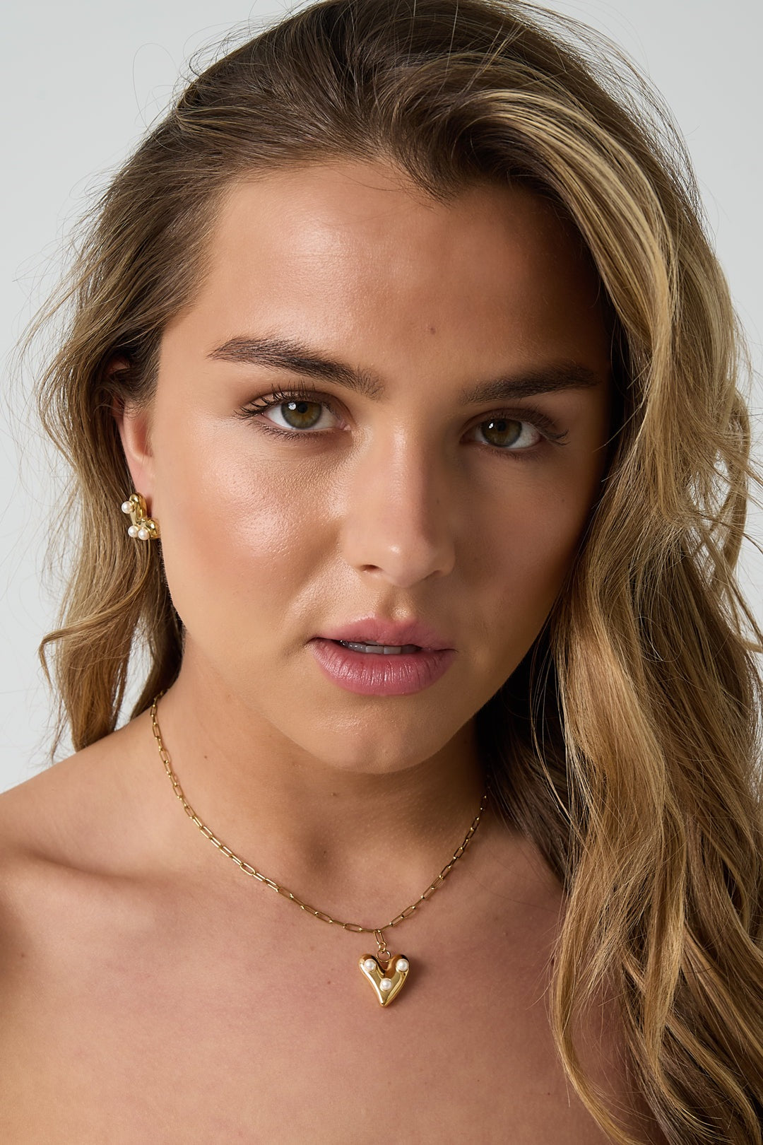 Model showcasing the pearl heart pendant necklace and earrings set, highlighting the youthful and soft jewelry style