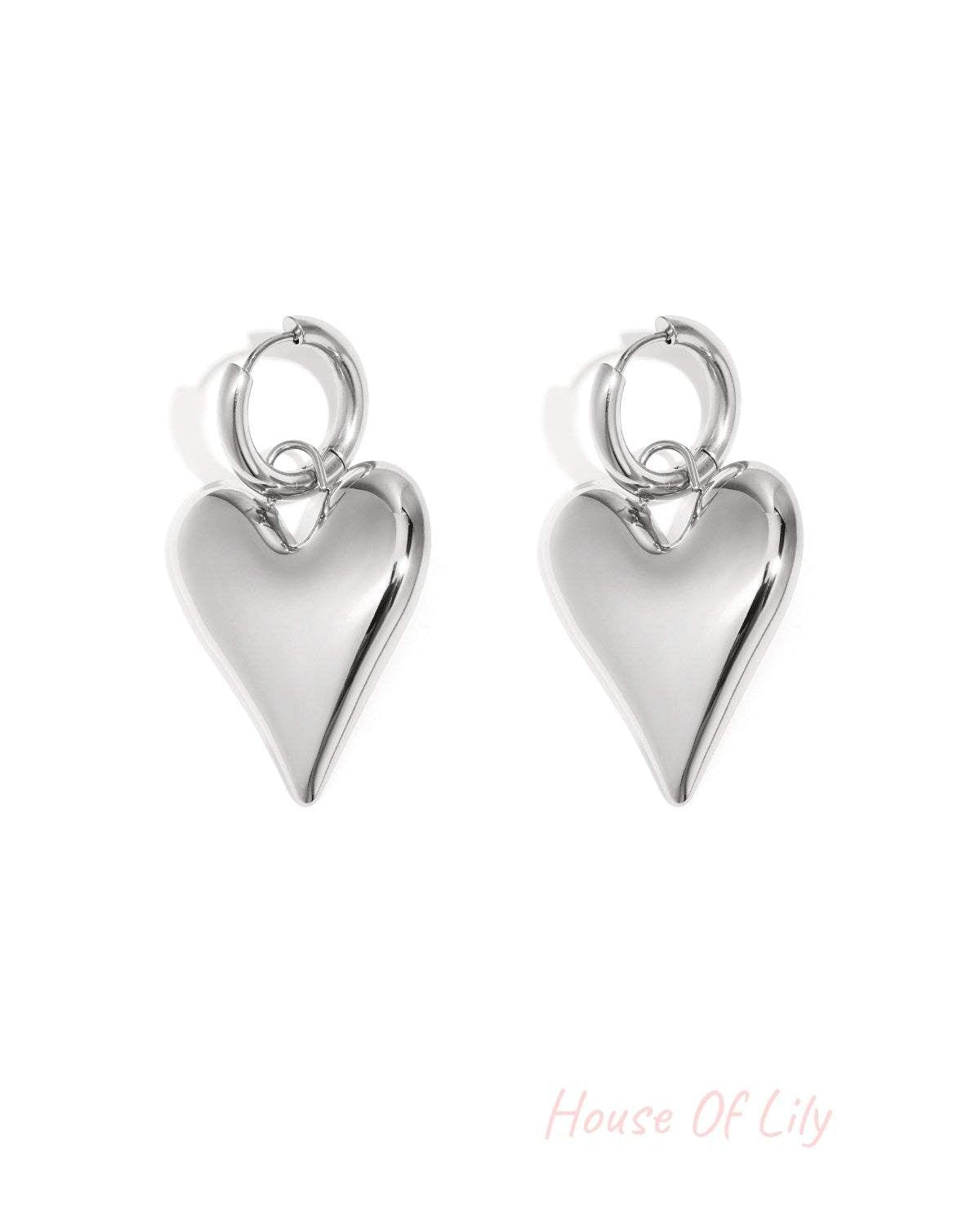 Pair of shiny silver chubby heart-shaped hoop earrings on white background
