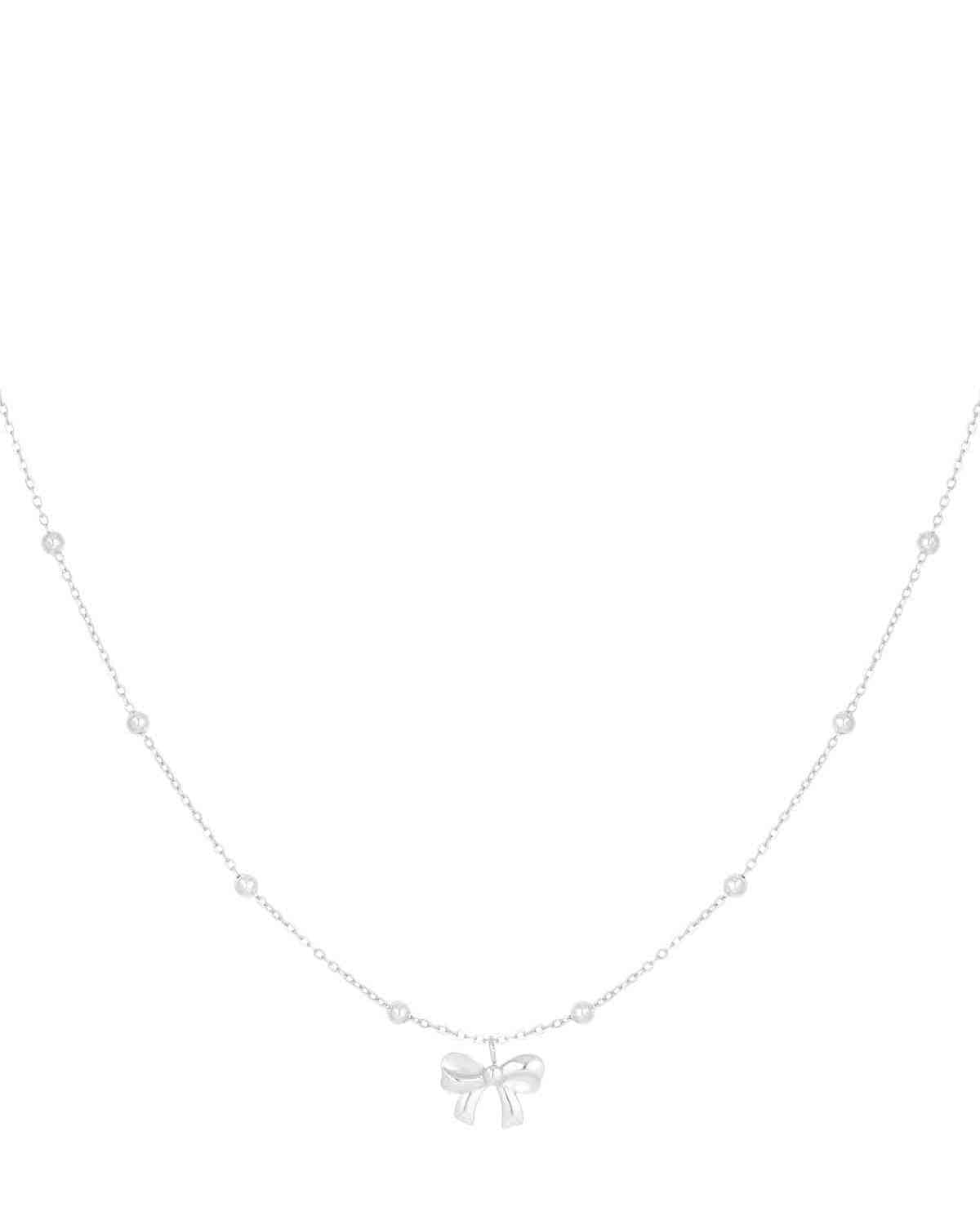 Silver delicate chain necklace with small round beads and a central bow pendant on a white background