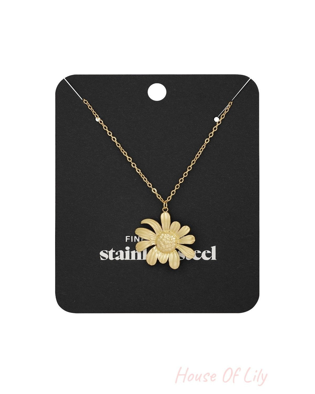 Golden daisy pendant necklace displayed on black branded packaging card highlighting fine stainless steel craftsmanship