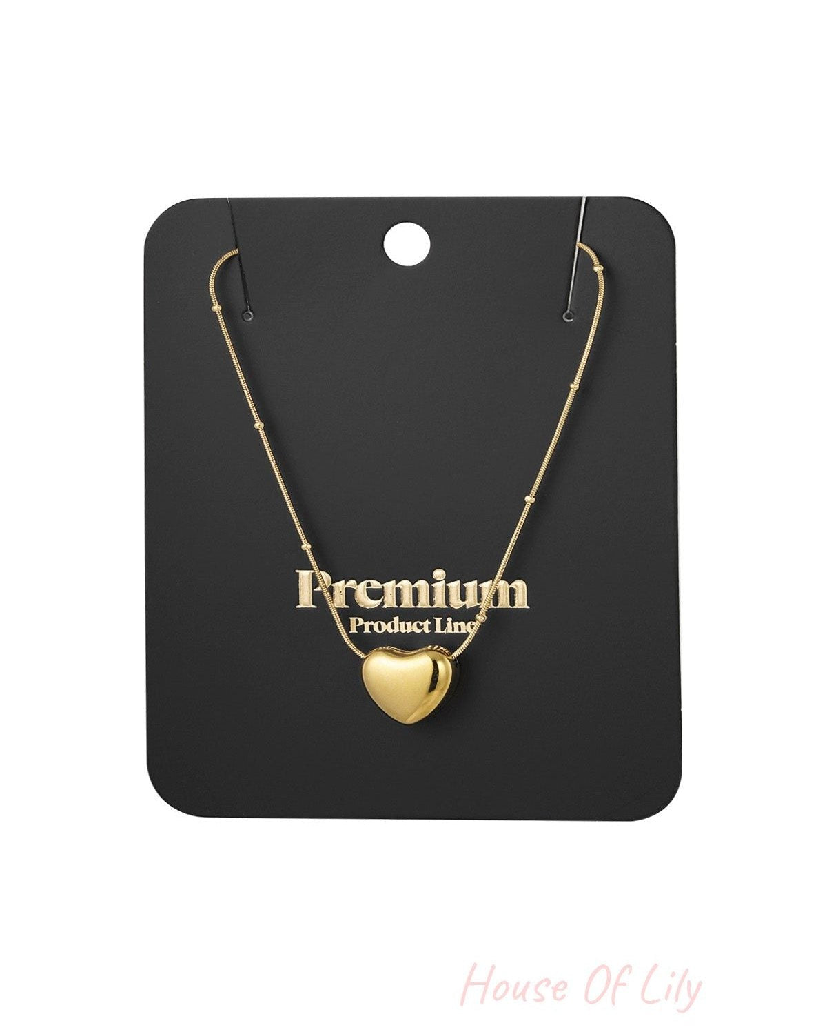 Gold heart pendant necklace displayed on black premium product line packaging card
