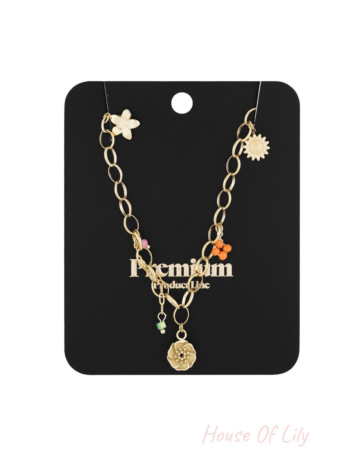 Gold chain charm necklace displayed on a black card labelled Premium Product Line