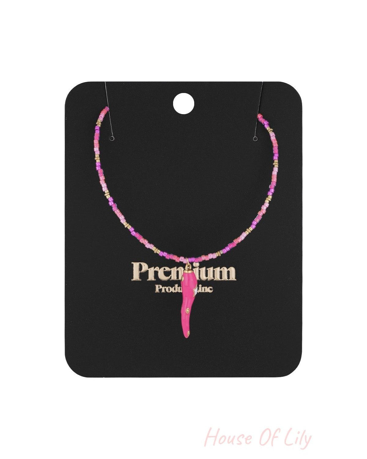 Pink and gold beaded choker necklace with chili pepper pendant displayed on black premium packaging card