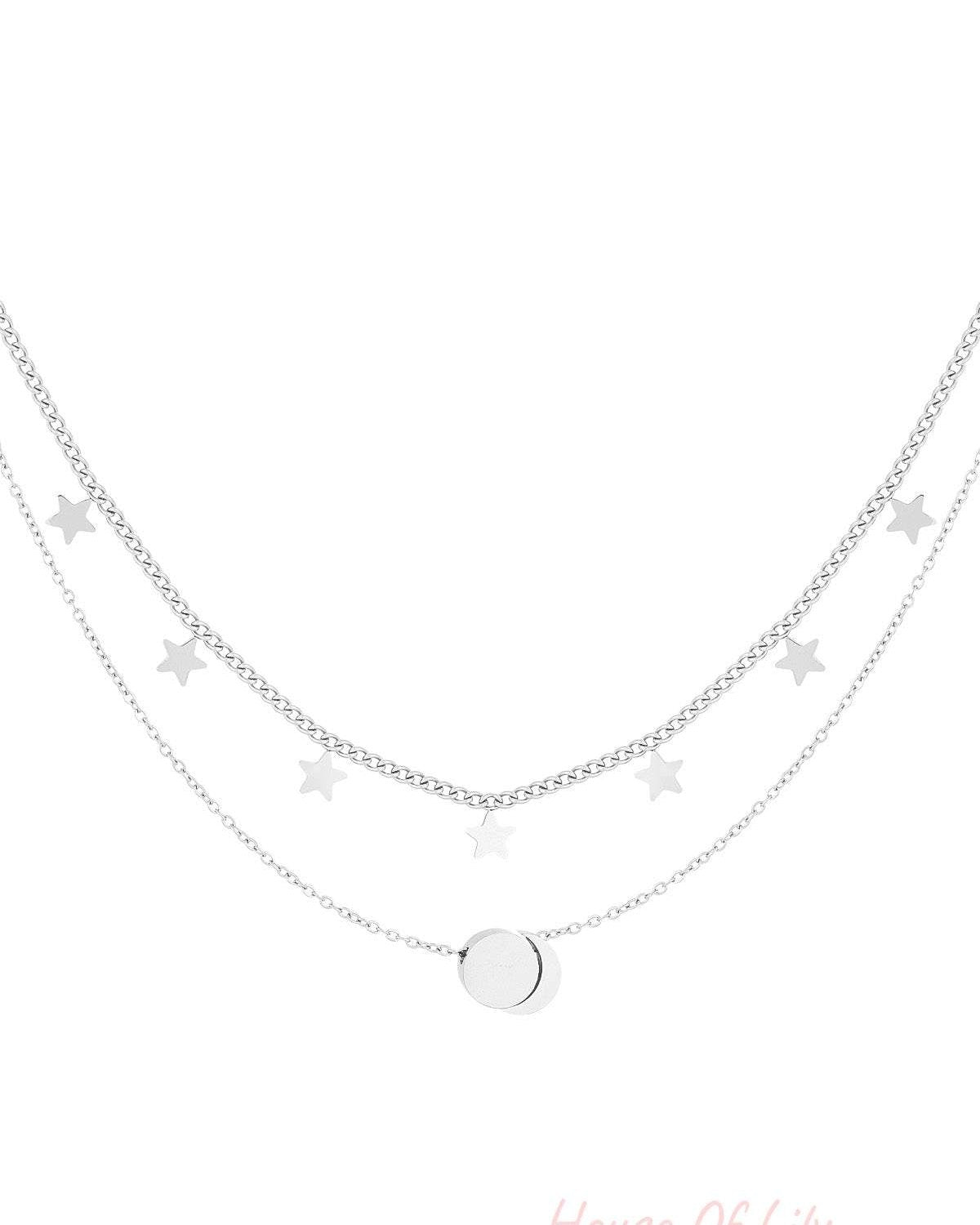 Silver layered necklace with star charms and round pendant on white background