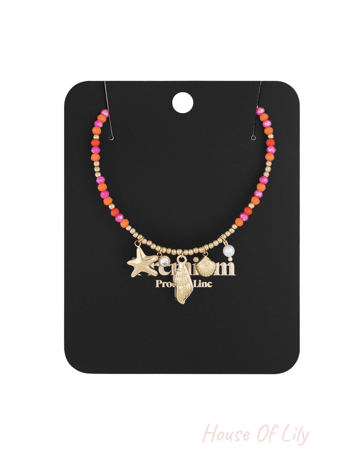 Necklace displayed on black packaging card showing the colorful beads and ocean-inspired gold charms