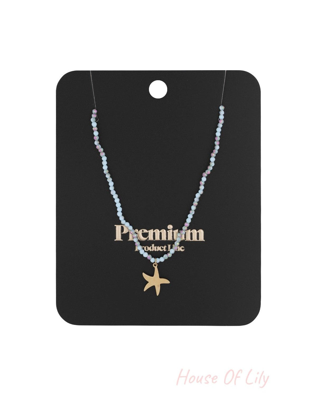 Beaded starfish charm necklace displayed on black premium product card packaging