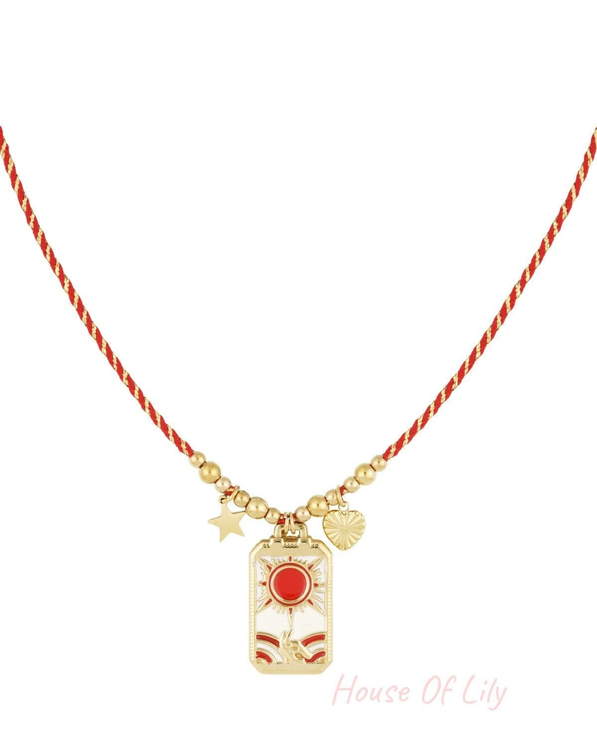 Solar charm necklace with red braided cord and gold-tone sun, hand, star, and heart charms on white background