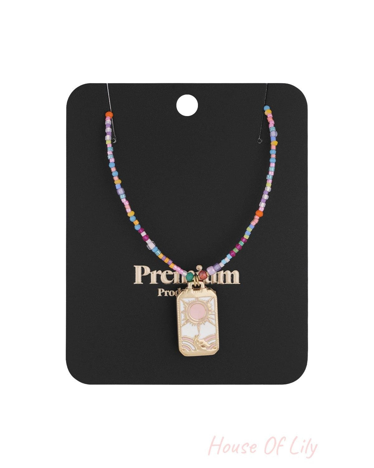 Colorful beaded sun charm necklace displayed on black premium product card