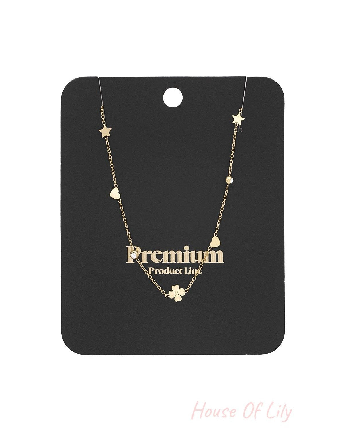 Gold-tone necklace displayed on black premium product card highlighting its charm details