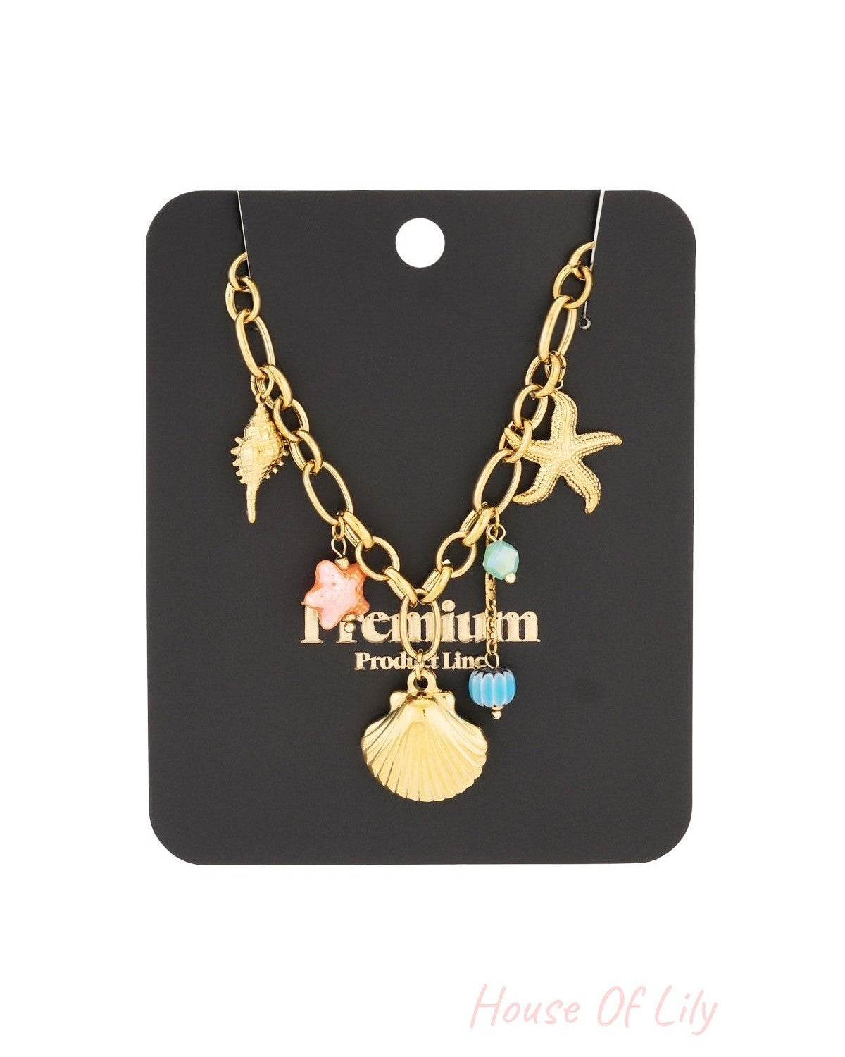 Gold necklace with sea-themed charms displayed on black product card packaging