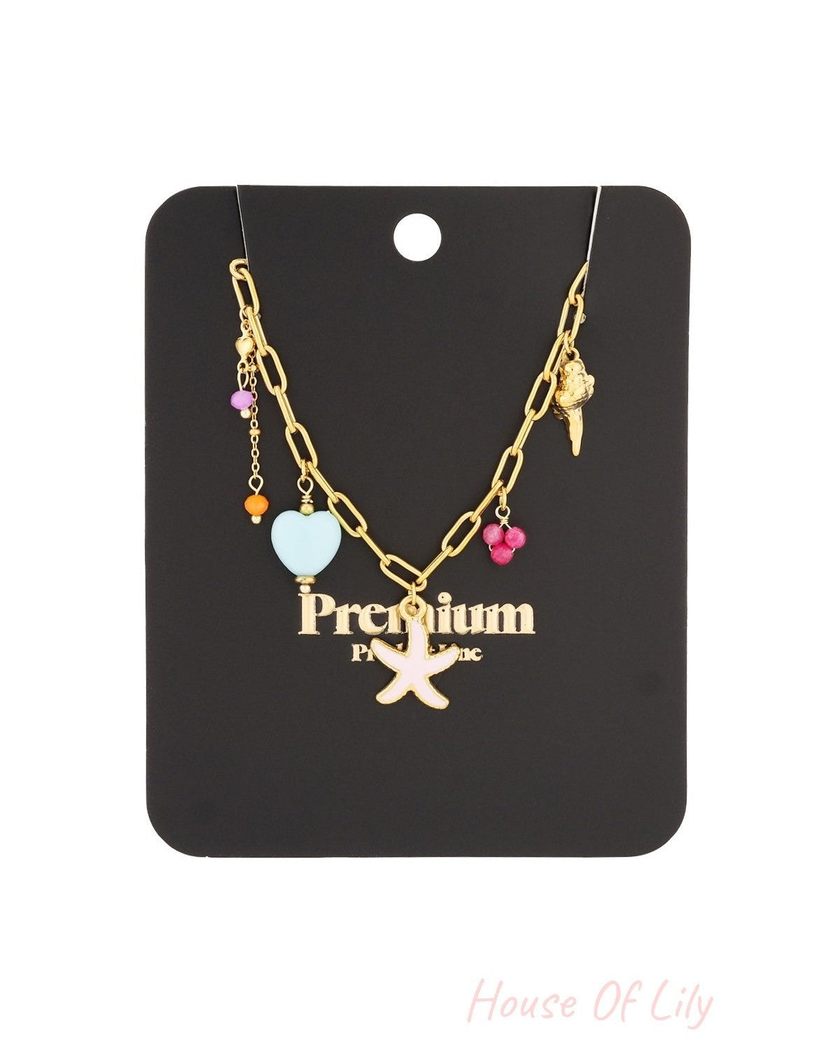 Gold-tone charm necklace displayed on black branded card, featuring starfish and seashell pendants and colourful beads