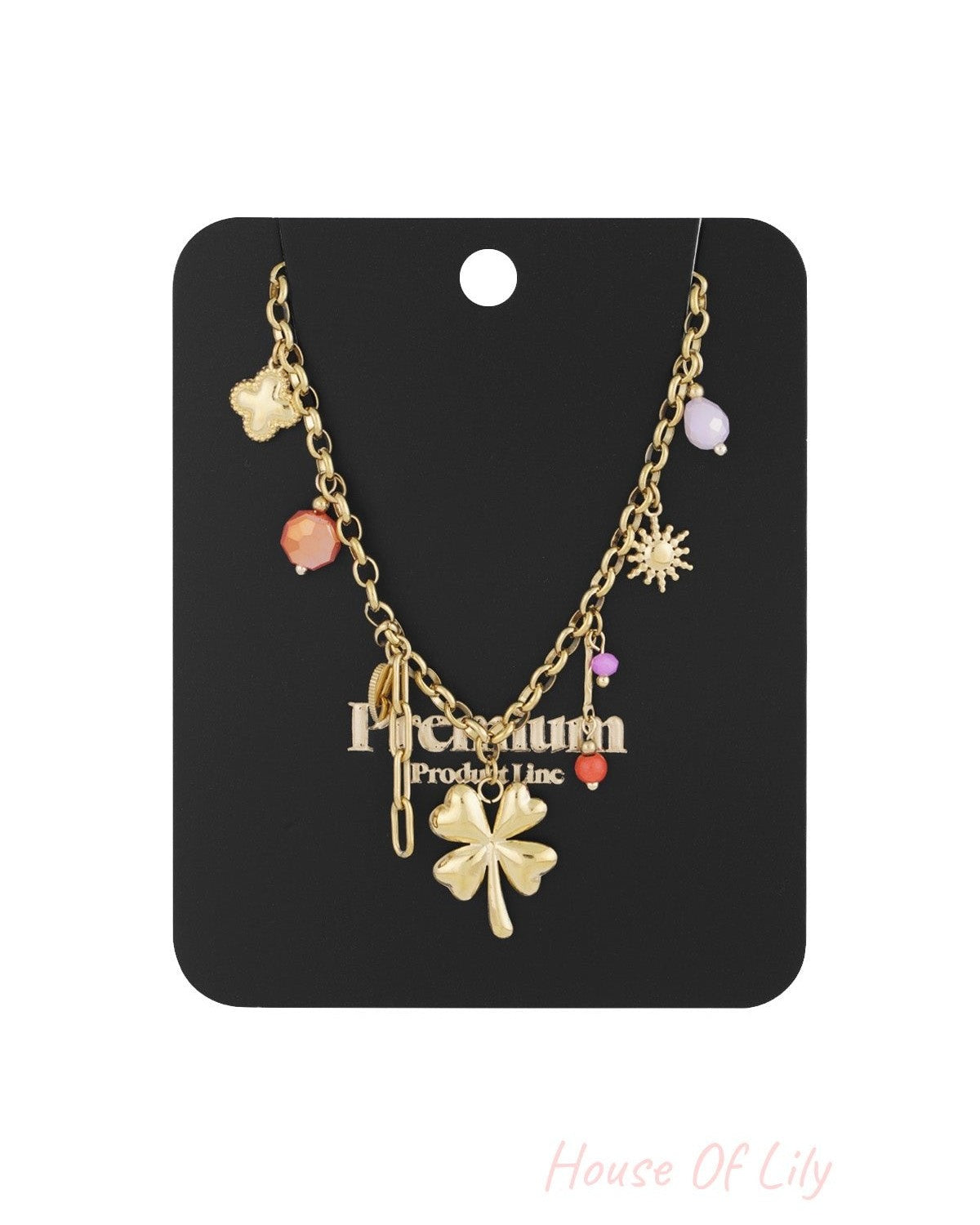 Gold-tone four leaf clover charm necklace displayed on a black product card