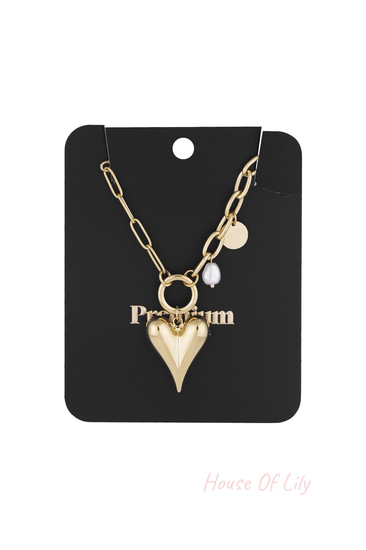 Gold-tone chunky heart pendant necklace with pearl and coin charms displayed on black packaging card