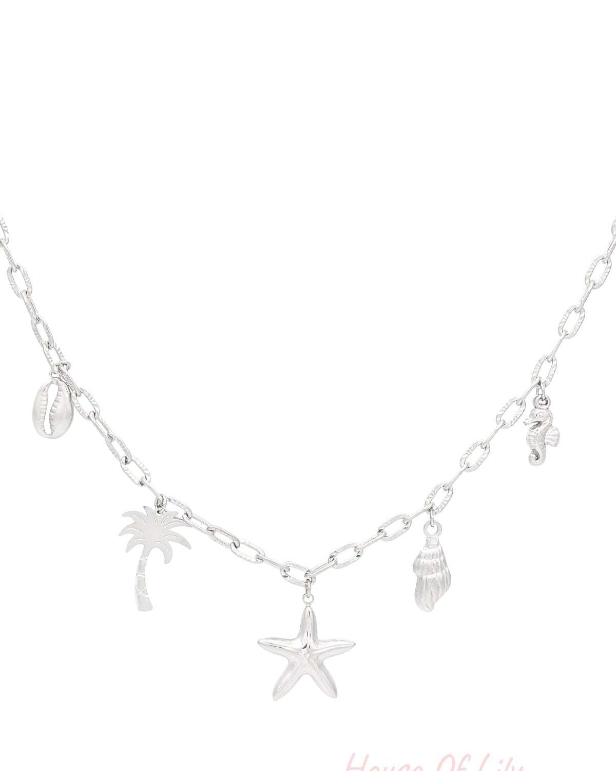 Close-up of silver seaside charm necklace with similar seaside charms on medium-link chain, highlighting shiny finish