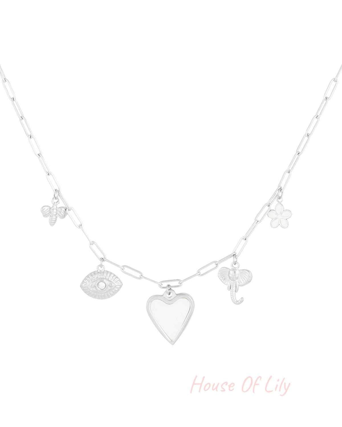 Silver tone charm pendant necklace with heart, bee, eye, elephant, and flower charms on paperclip chain against white background