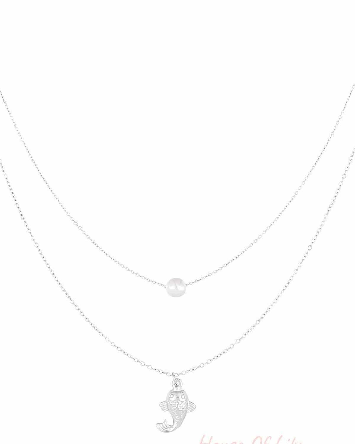 Silver layered necklace with a pearl and fish charm on white background
