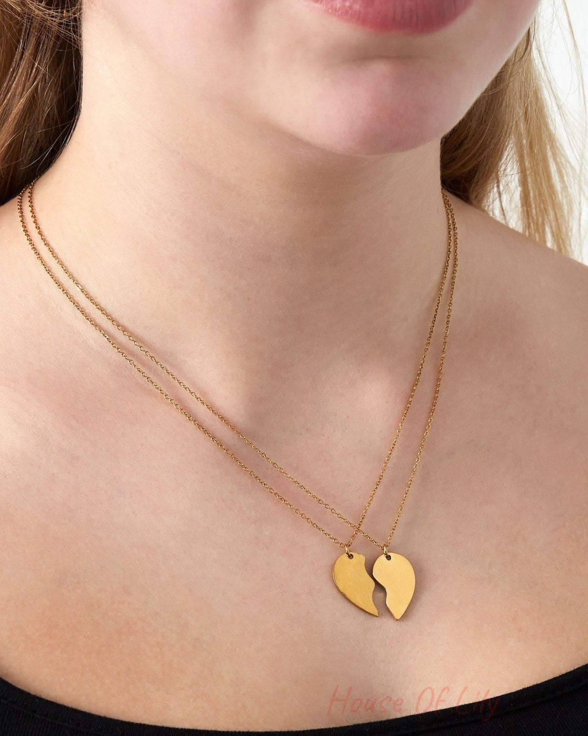 Close-up of a woman wearing a gold two-piece best friend necklace set with broken heart pendants