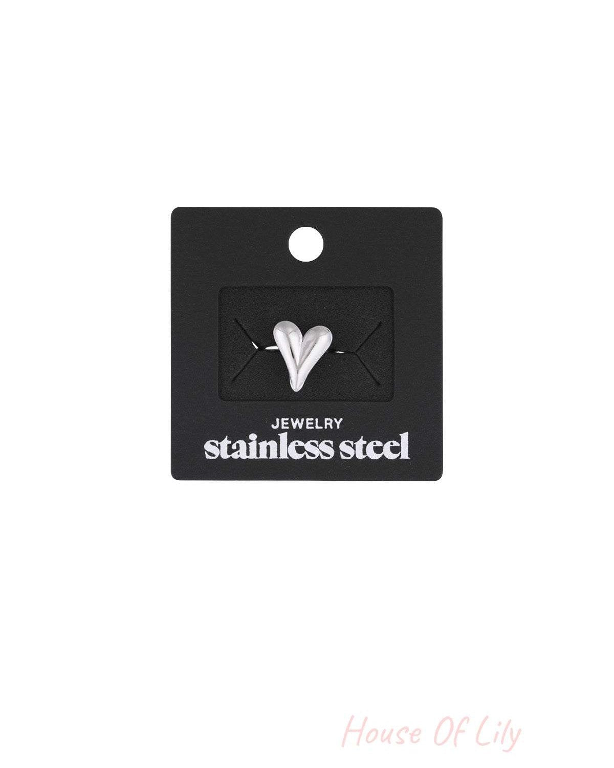 Silver heart statement ring displayed on black packaging card labeled stainless steel jewelry