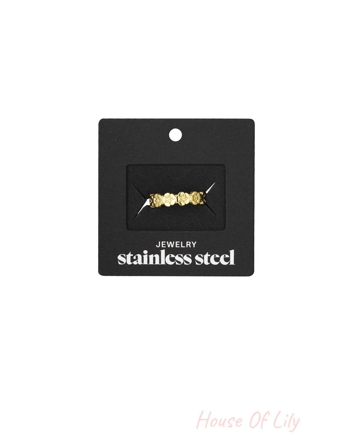 Gold floral open band ring displayed in black packaging labeled 'stainless steel jewelry'
