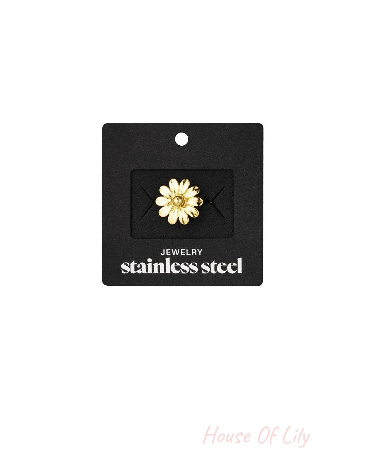 Gold daisy flower ring attached to a black display card labeled 'stainless steel jewelry'