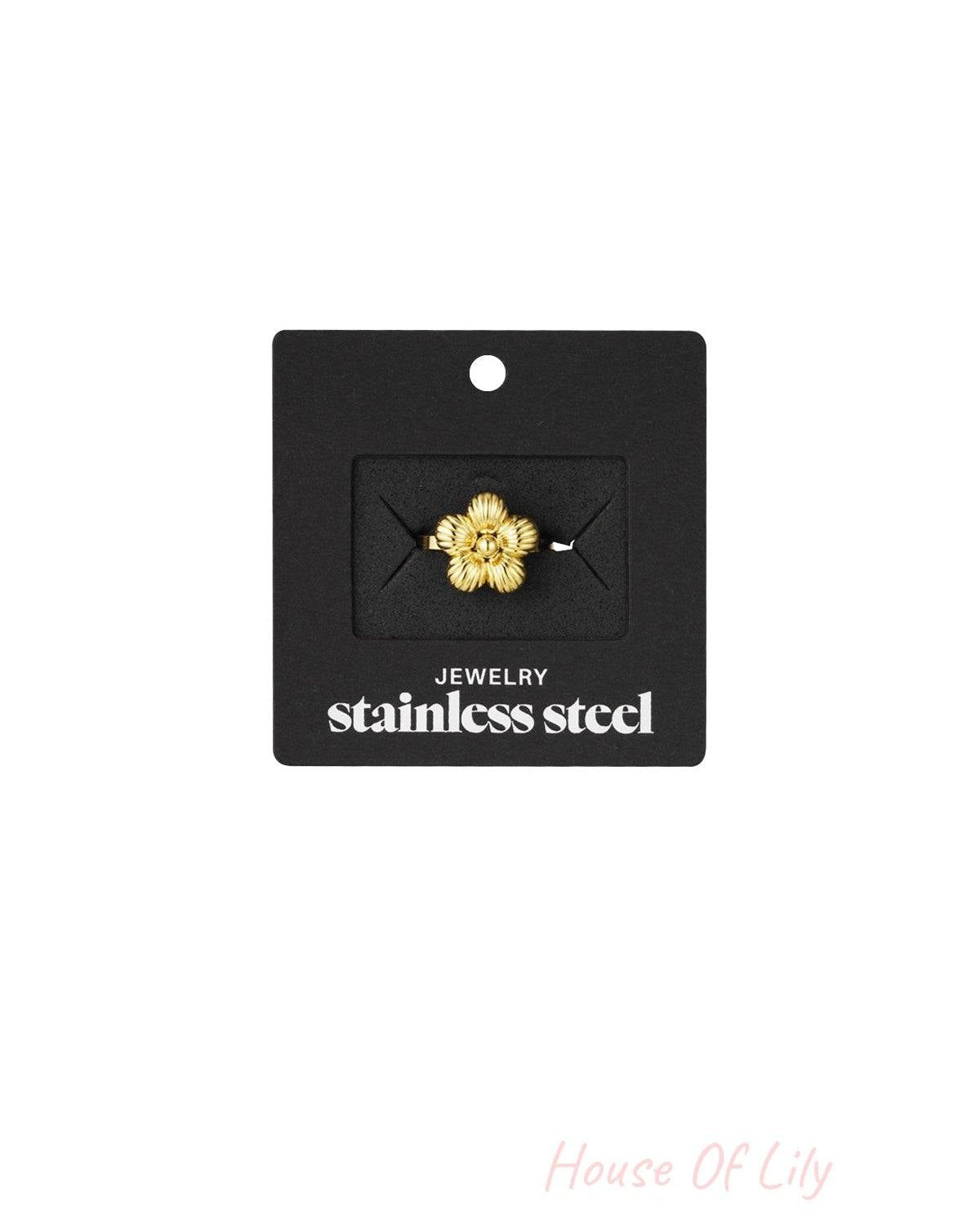 Gold floral ring displayed on black packaging card labeled 'stainless steel jewelry'