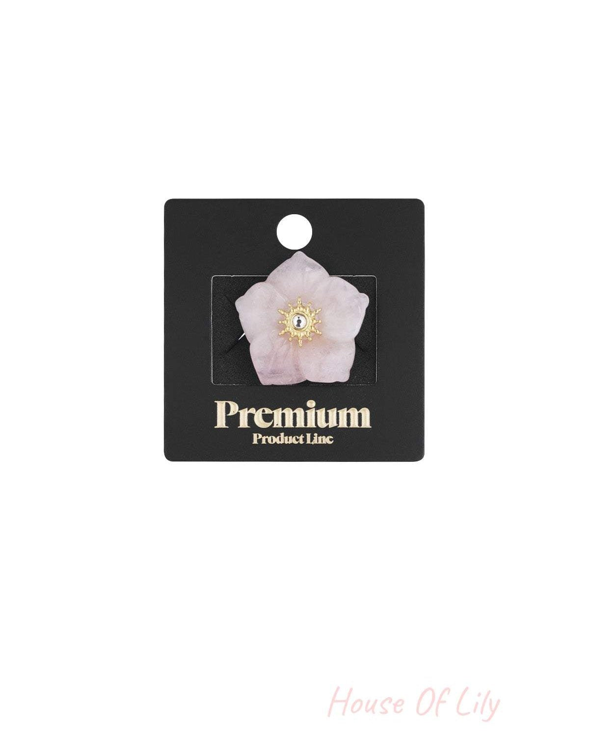 Pink floral statement ring displayed on black Premium Product Line card