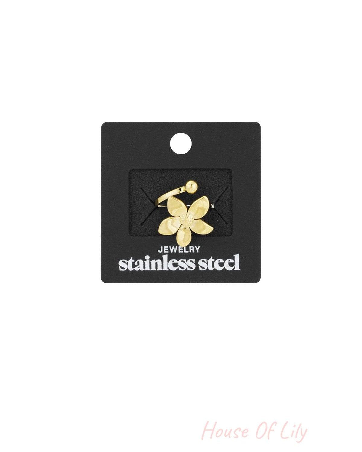 Gold flower statement ring displayed on black packaging labeled 'stainless steel jewelry'