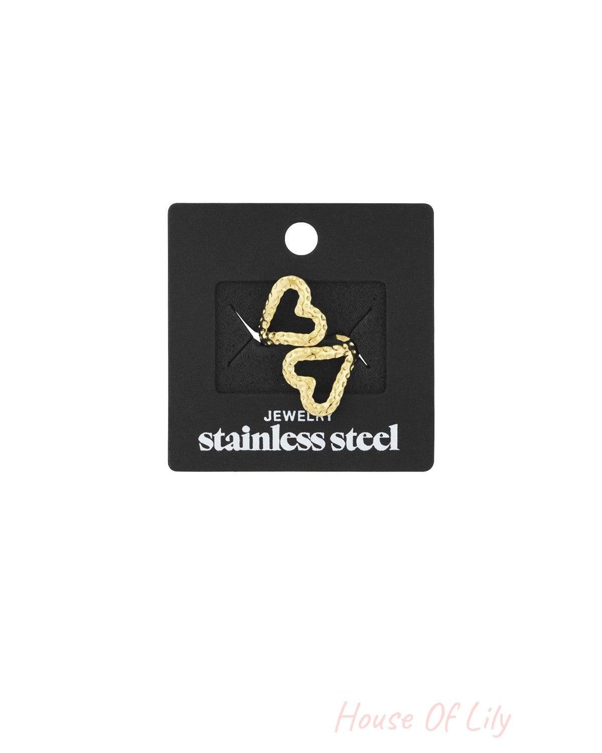Gold textured open heart ring displayed on black packaging card labeled stainless steel