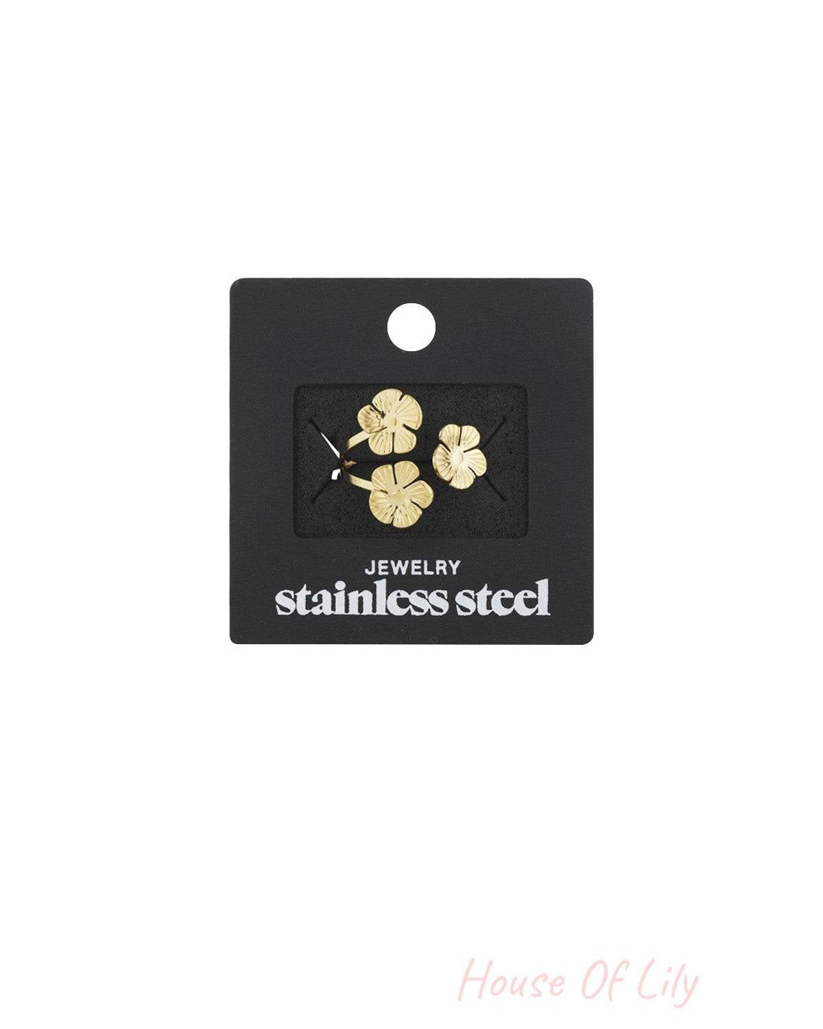 Gold floral trio ring displayed on black card labelled stainless steel jewelry