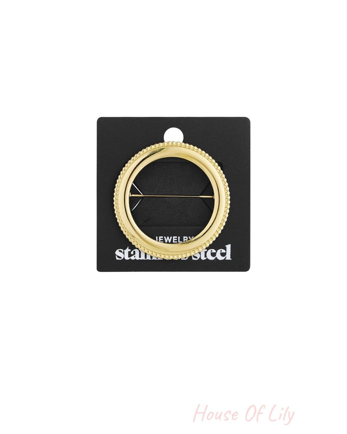 Gold circle brooch attached to black packaging card labeled stainless steel jewelry, highlighting secure pin fastening