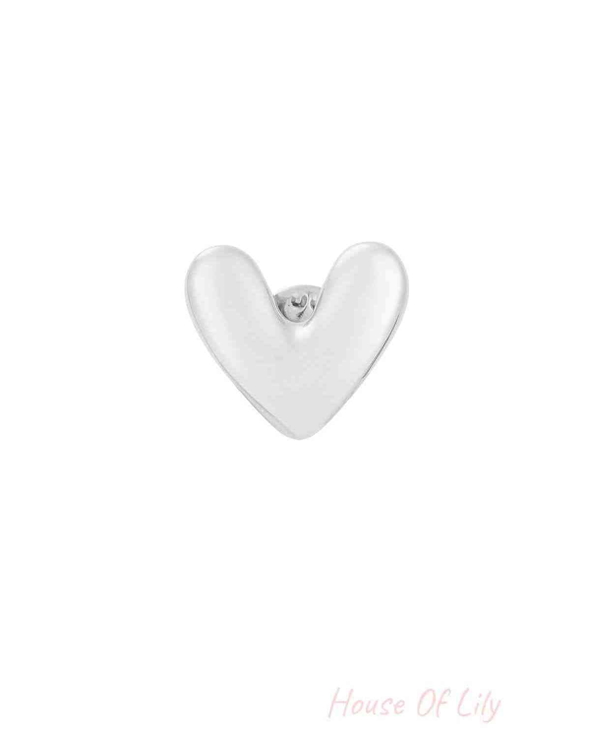 Silver polished heart brooch with smooth rounded edges on a white background