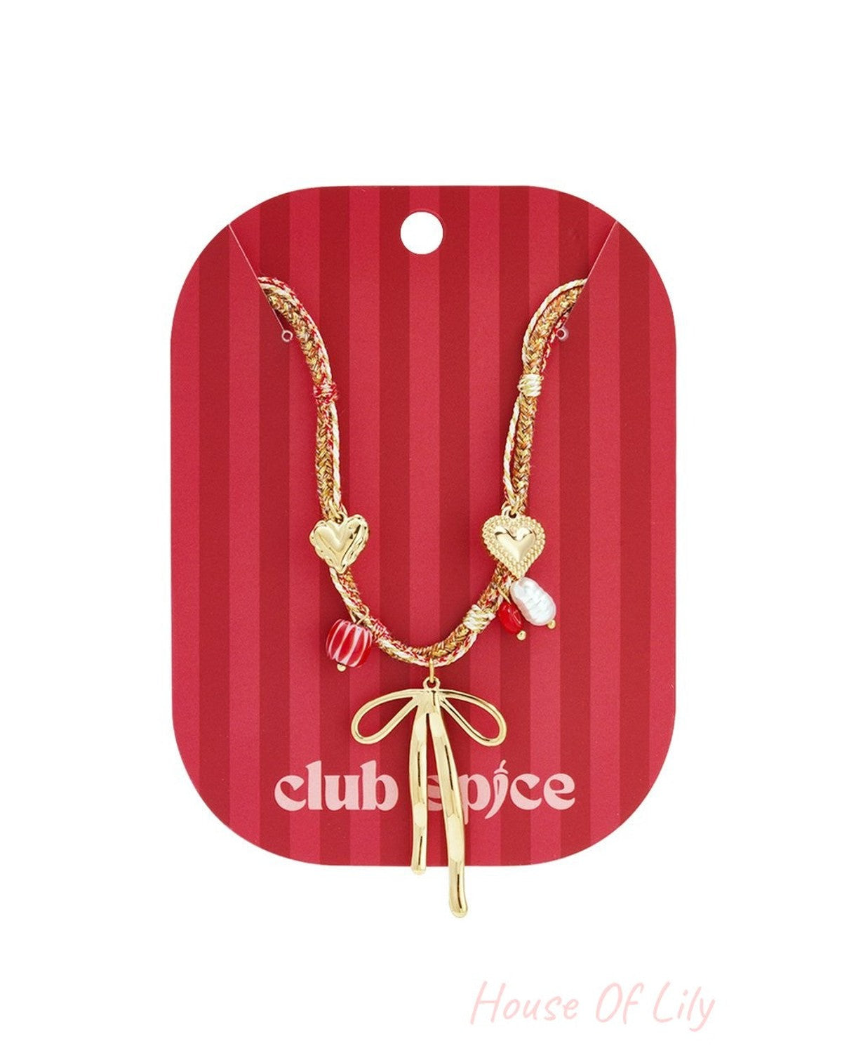 Gold chain necklace with a central bow charm, heart, pearl, and striped red beads on a red-striped backing card.