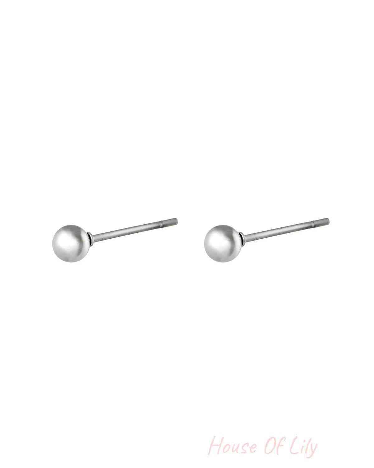 Pair of minimalist silver ball stud earrings isolated on white background