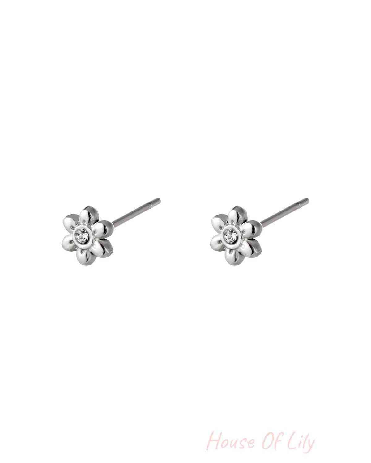 Pair of silver floral mini stud earrings with rhinestone center on white background