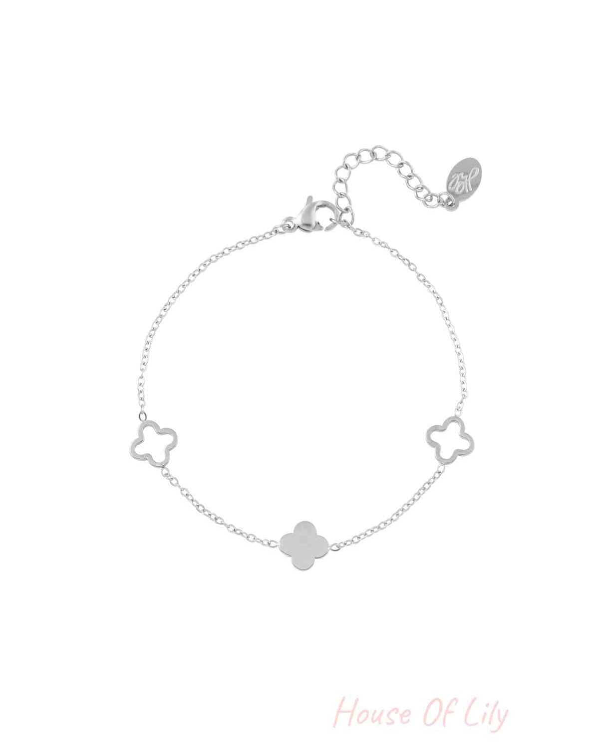 Silver clover charm bracelet with adjustable chain laid flat on a white background