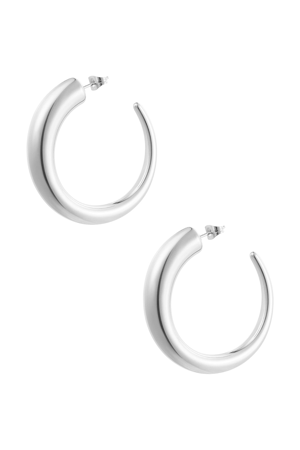 Pair of chunky silver curved hoop earrings on white background